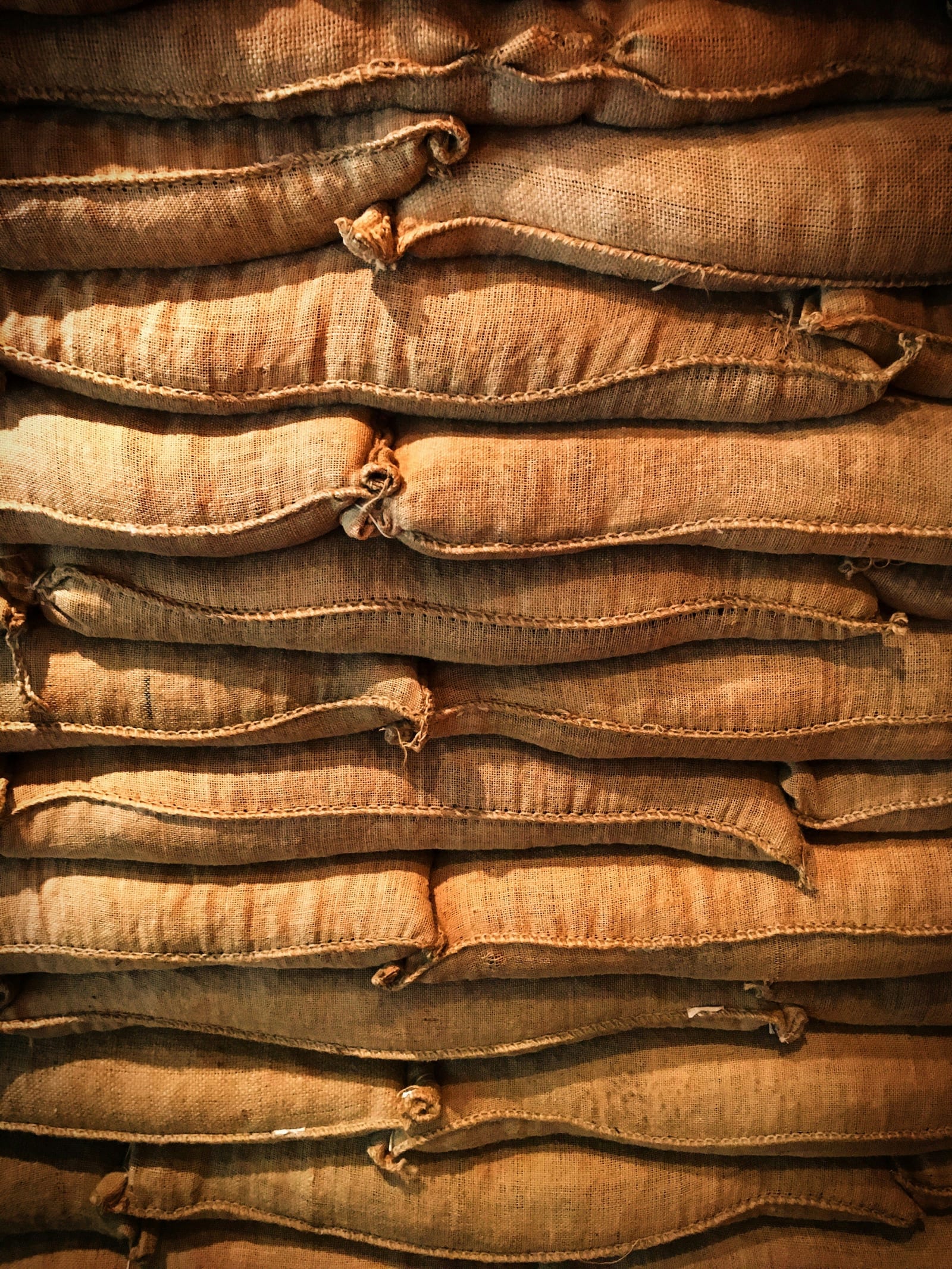 Jute sacks of green coffee stacked in a warehouse
